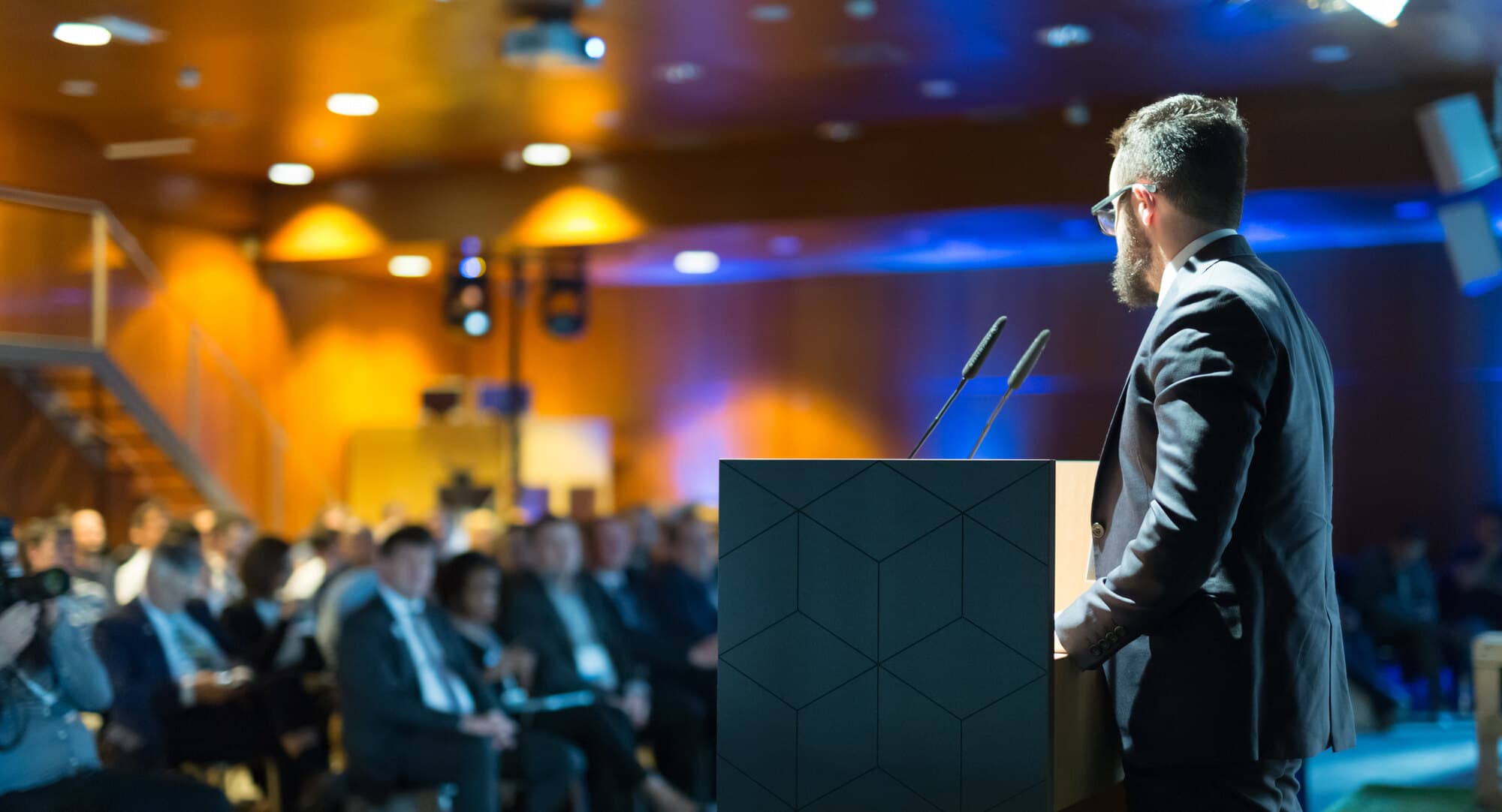 A speaker presenting at a healthcare business conference